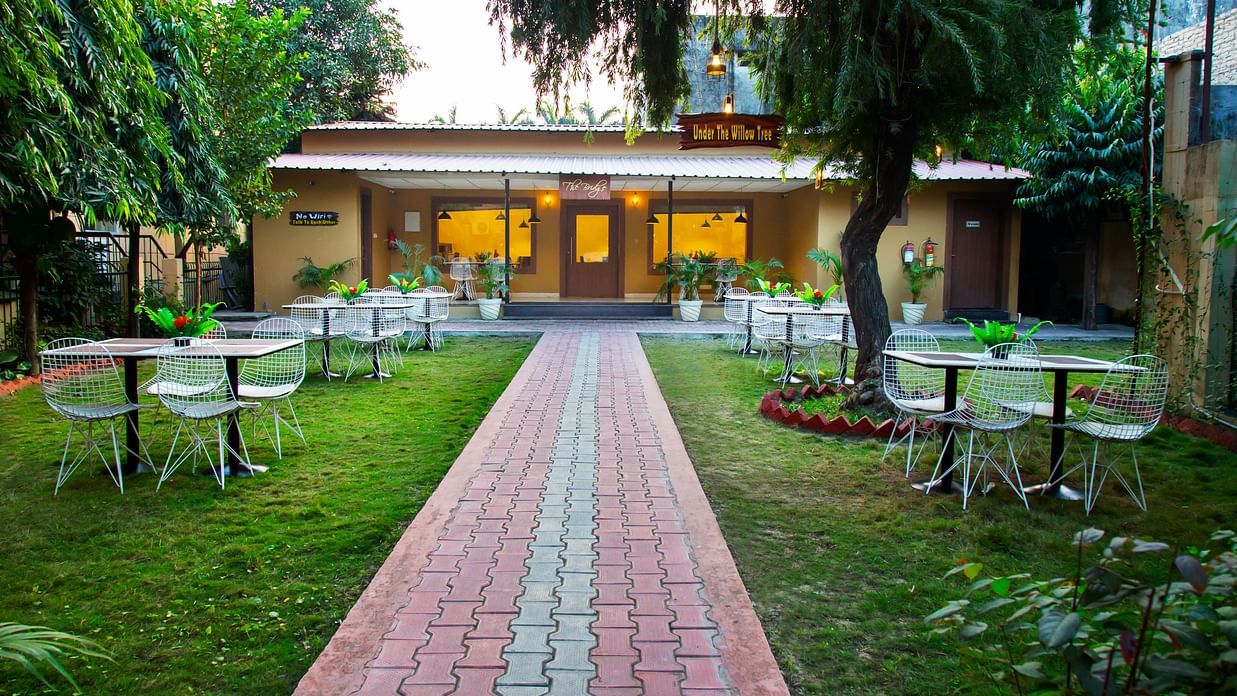 Restaurant pathway with bright lights and arranged table and white chairs