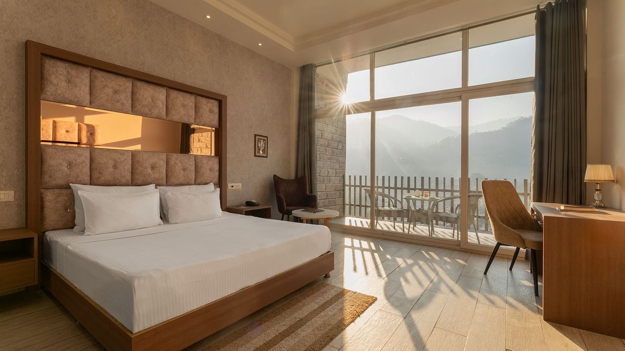 A hotel room provides a bed with a scenic view through a large window - SPT Clarks Inn Suites, Mandi