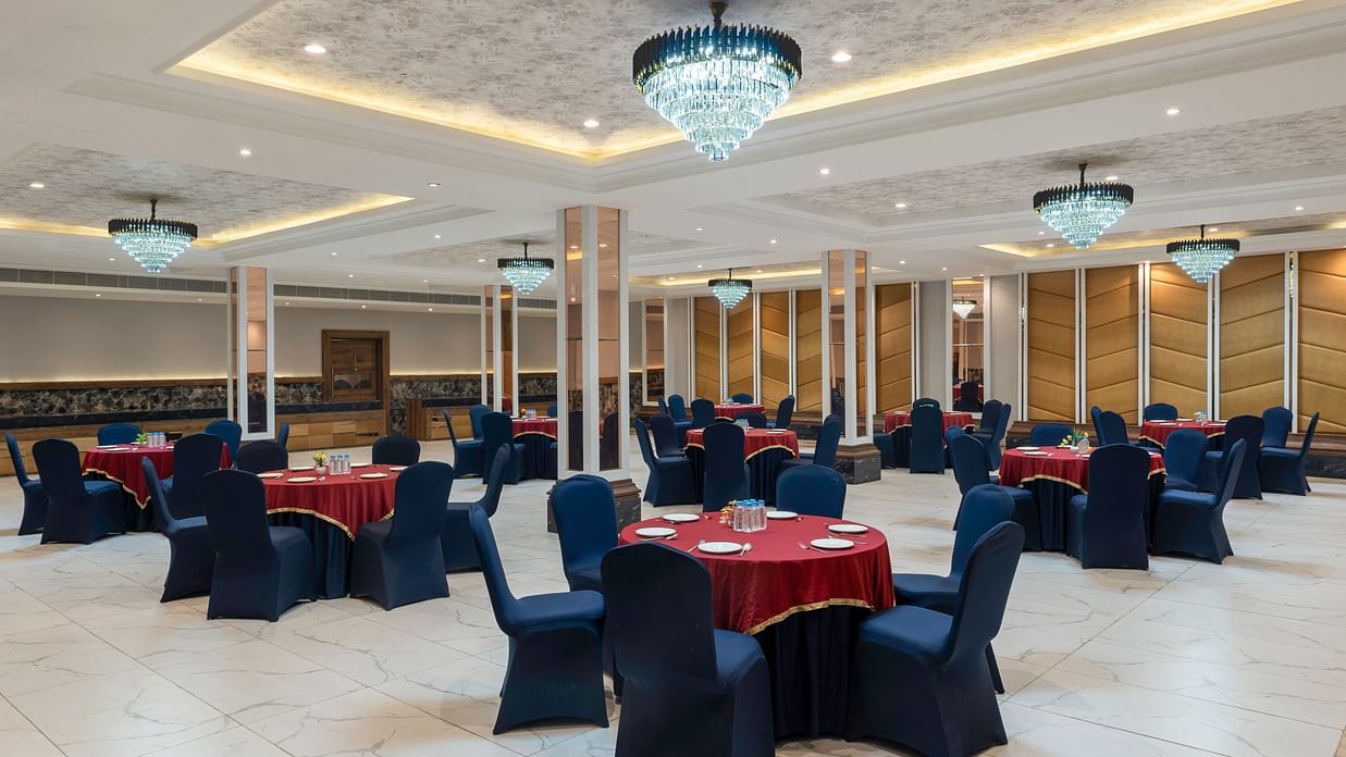 A banquet area is set with tables and chairs, ready for meals -SPT Clarks Inn Suites, Mandi