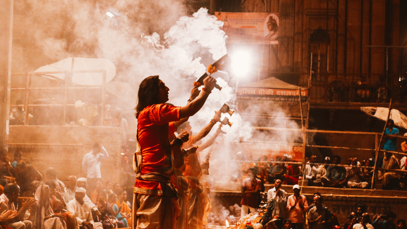Men stand amidst a crowd holding chalices with smoke coming out of it