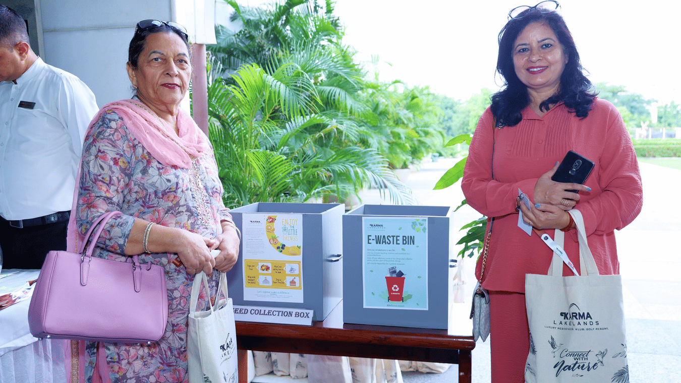Woman posing with event memorabilia outdoors - Karma Lakelands.