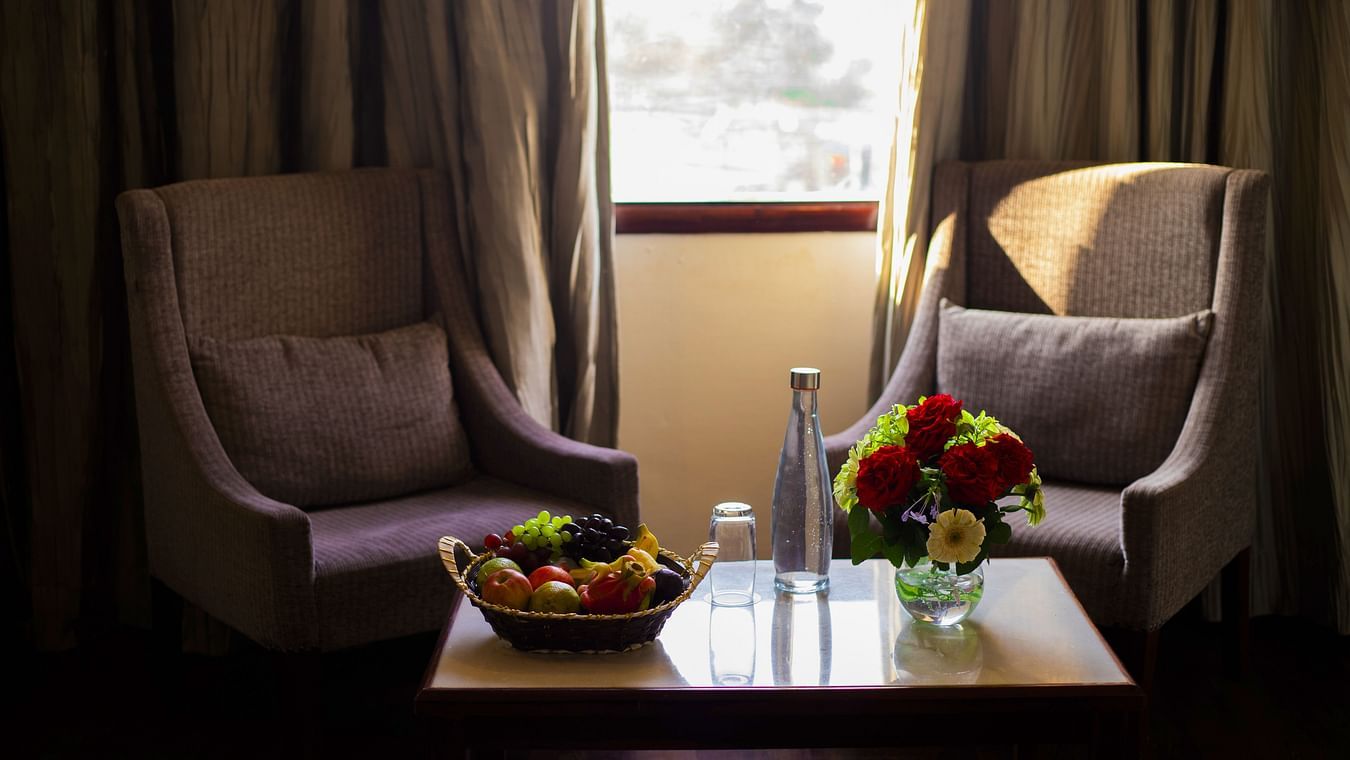 Deluxe room with sofa and fruits kept on table