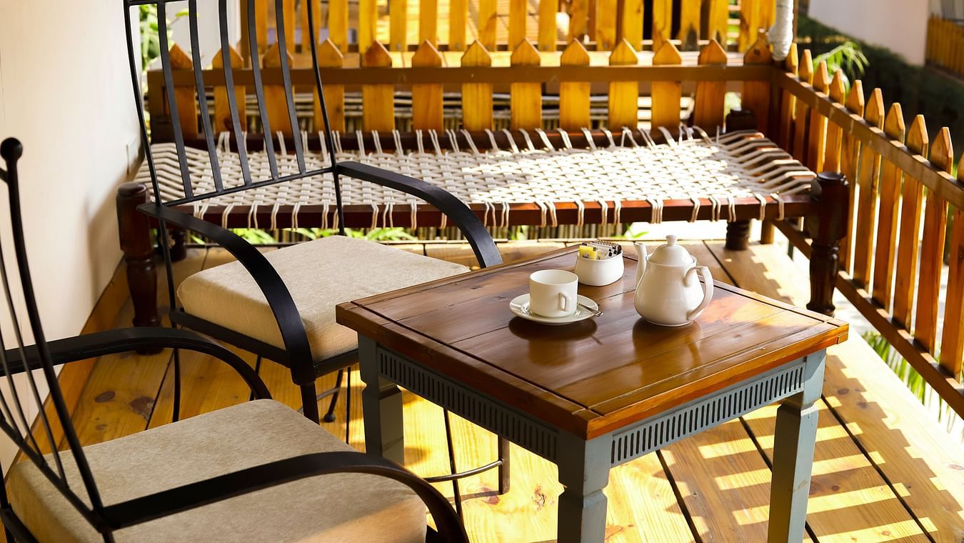 A wooden table with teacups and chairs