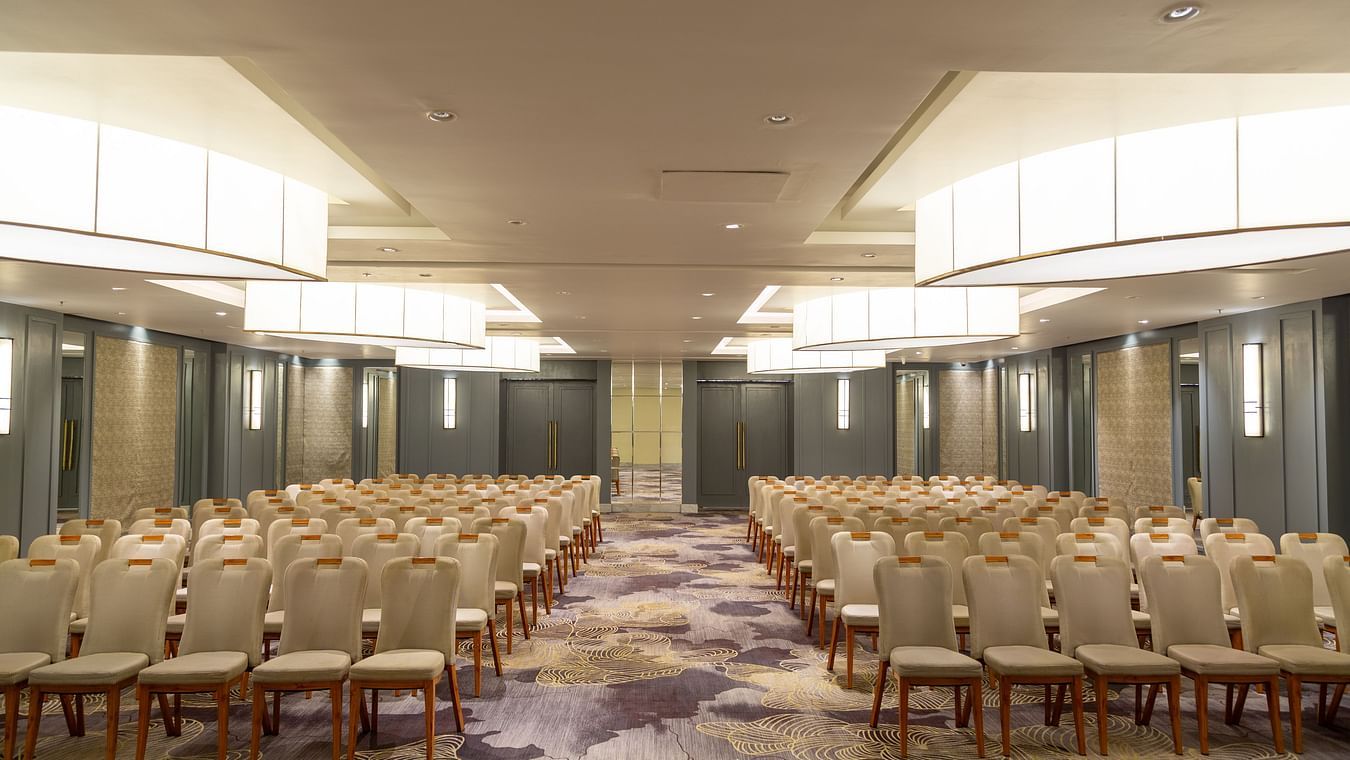 Spacious banquet hall with interior lighting and neatly arranged chair seating at The Residency Towers Puducherry