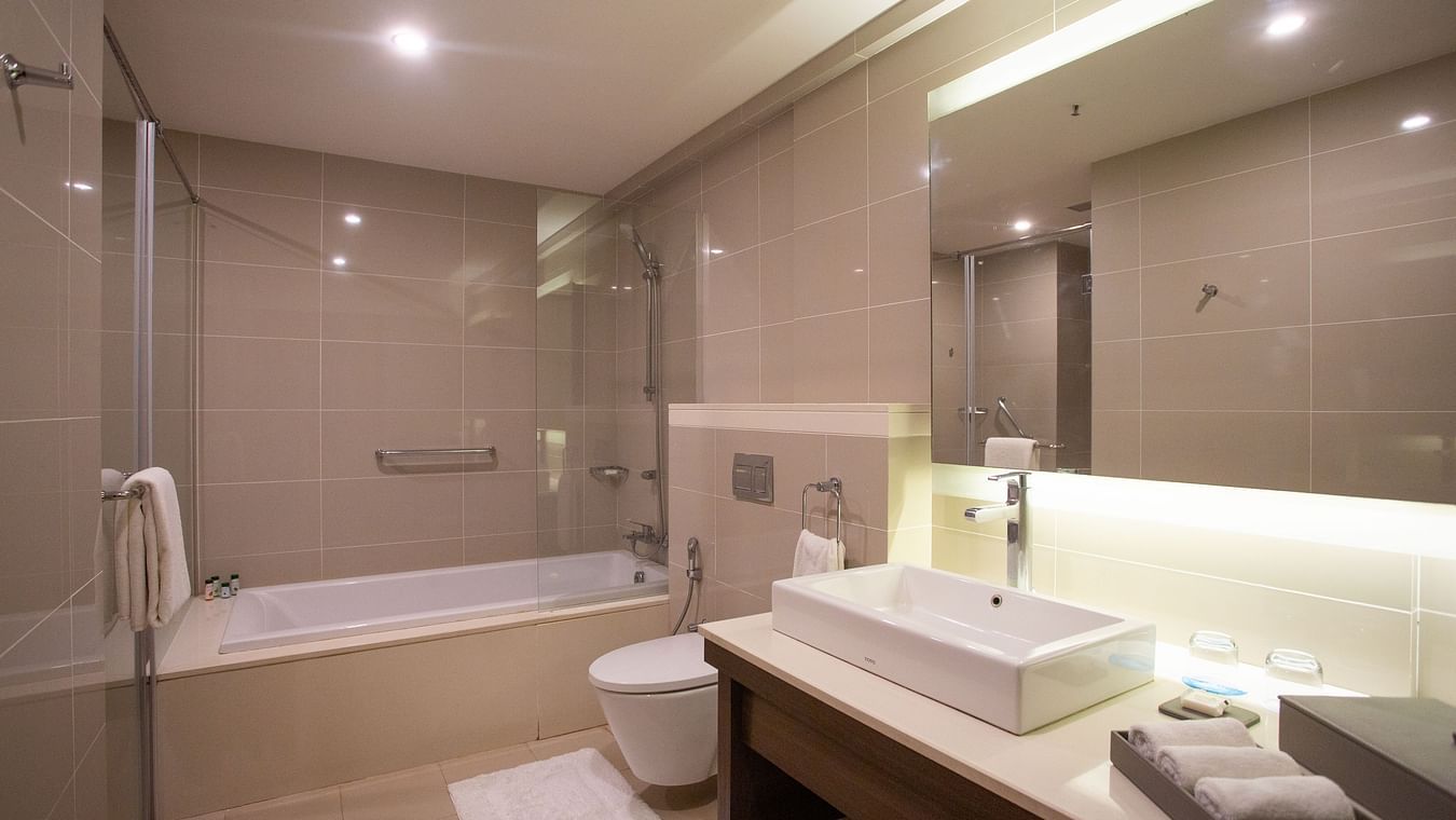 A spacious bathroom featuring a wash basin area and a large bathtub at The Residency Towers Rameswaram