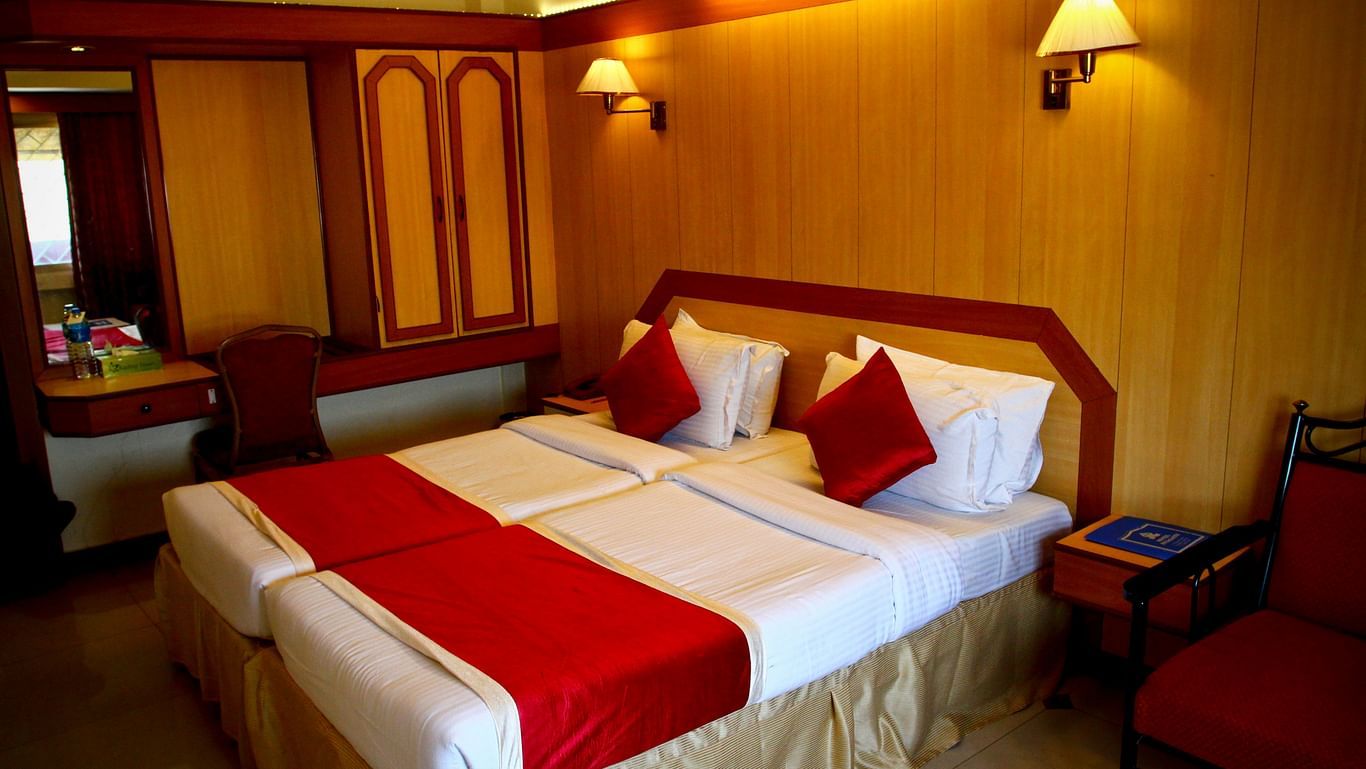 a view of an room with bed, wardrobe and look glass placed by its side - Hotel Swagath, Bangalore