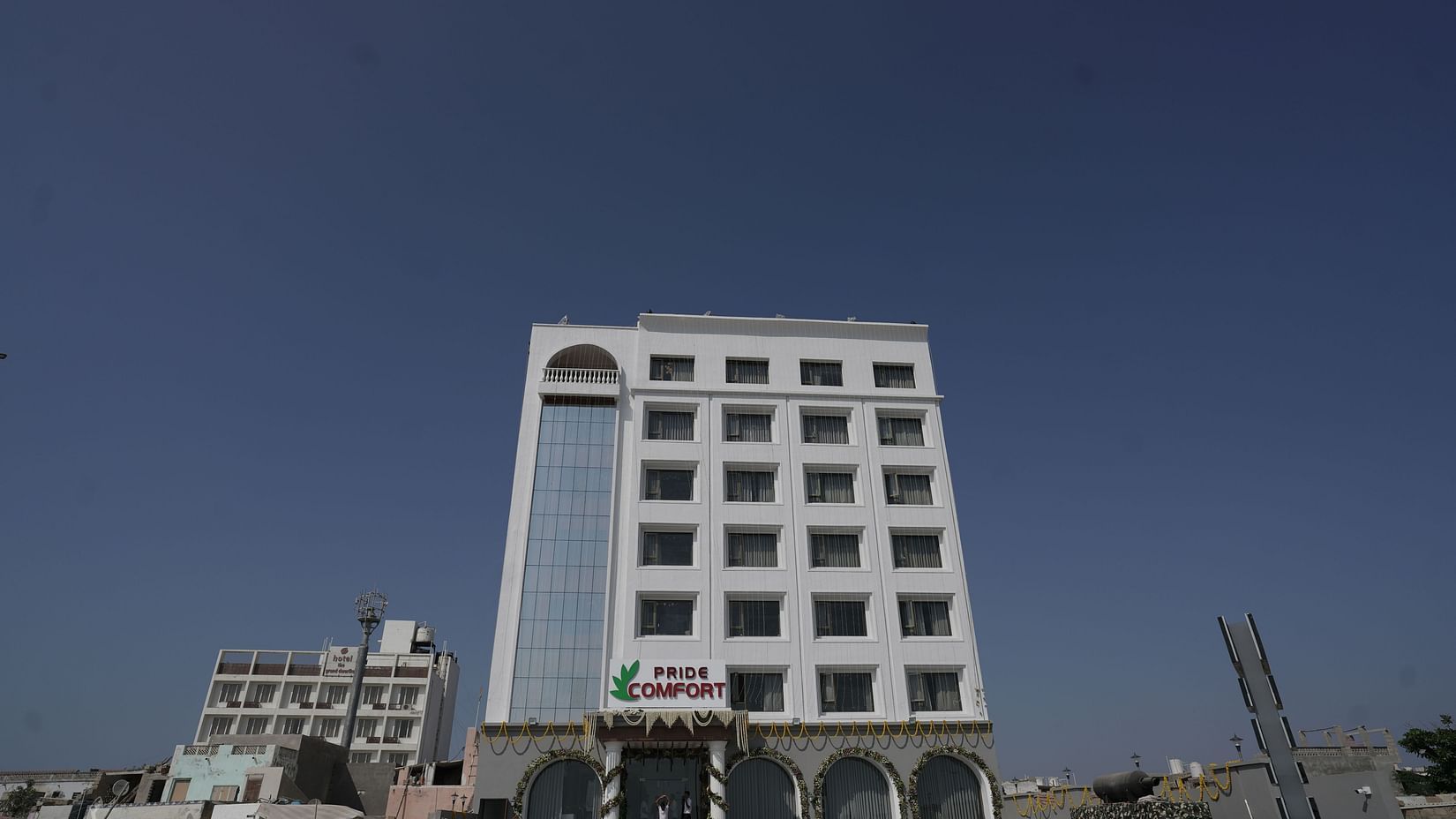 Facade of Pride Comfort, Dwarka on a clear blue day