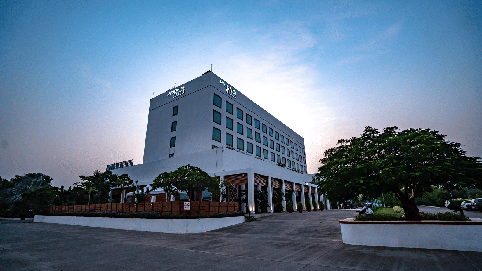 Exterior view of Pride Elite Phaltan hotel building with driveway and landscaped surroundings.