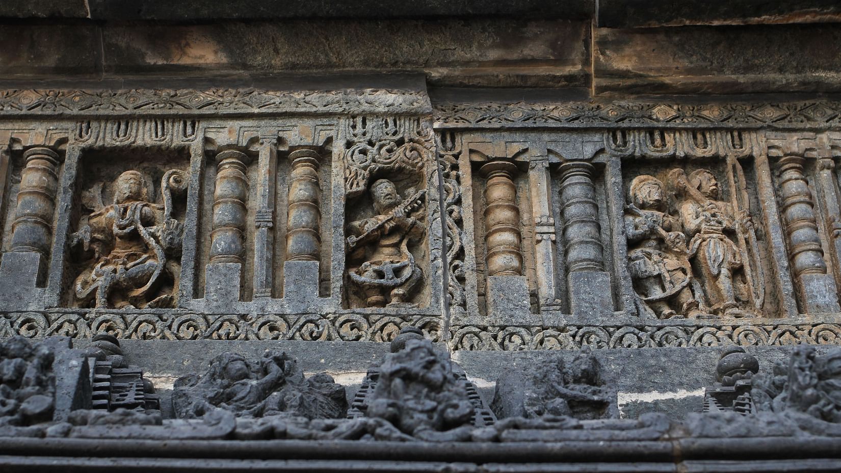 carvings of idols on a stone wall