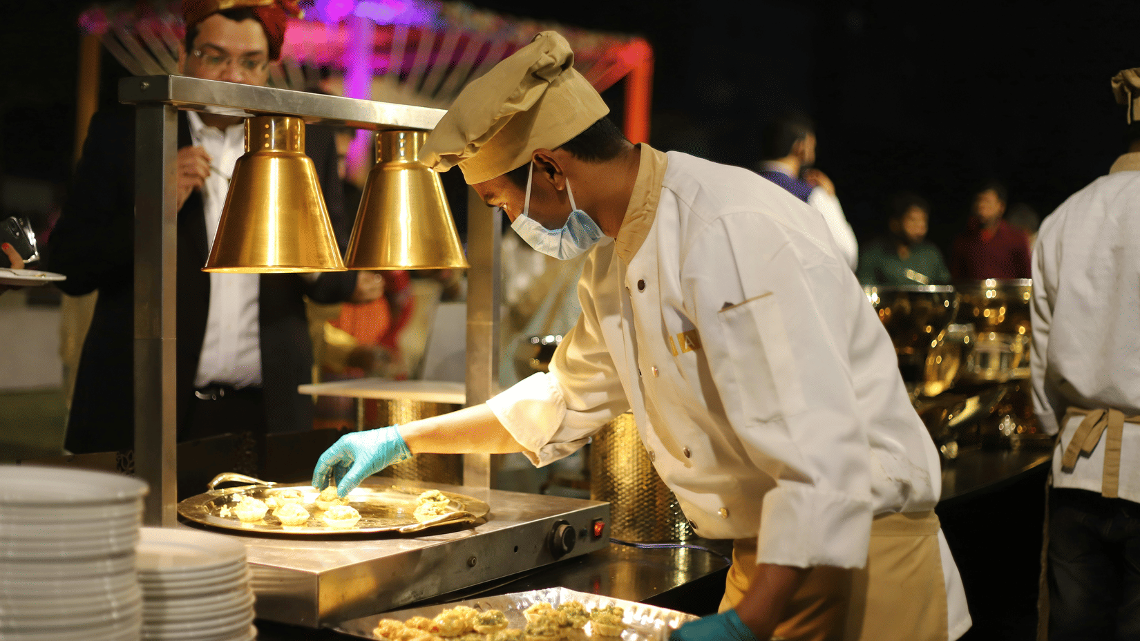 A chef preparing fresh appetisers at a live catering station during an outdoor event.