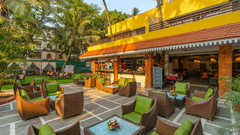 An image of an outdoor seating area with beautifully arranged seating, adjacent to a restaurant and bar.