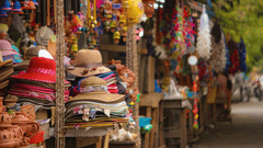 Street vendor selling hats and various accessories displayed on a table.