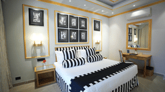 An Executive Suite bedroom at Clarks Khajuraho with a neatly made bed, patterned bedding, framed artwork above the headboard, and side lamps.