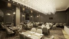 Restaurant with tables and chairs having lights on the ceiling at Classic Sapphire by Ananta