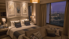 Rooms in Bhavnagar, Efcee Sarovar Premiere, featuring double size bed, bedside table with lamps, and a seating area with sofa.