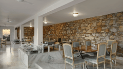 A restaurant at Fateh Safari Suites, Kumbhalgarh featuring sets of tables and chairs and food counters