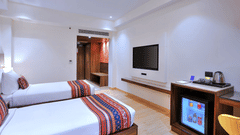 An image of twin bed, a minibar and a television in our room in Agra - Golden Tulip, Agra