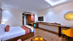 An image of a beautiful room in Agra with a large bed, a flat-screen television and furniture to sit and relax on - Golden Tulip, Agra