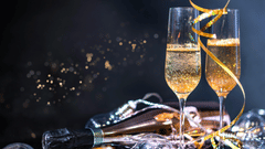 2 flutes of sparkling champagne sit amidst festive tinsel and bubbles | New years eve Gurgaon