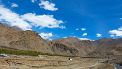 A rocky valley with a winding road along the side.