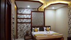 A modern luxury hotel bedroom in Varanasi, showcasing elegant decor, ambient lighting, and comfortable furnishings available through exclusive Varanasi hotel deals - Hotel Uday Palace.