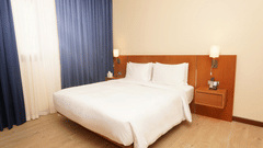 a double bed with side tables and lamps inside Classic Apartment - La Maison Hotel, Doha