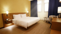 a king bed with side tables and lamps inside Deluxe Apartment - La Maison Hotel, Doha