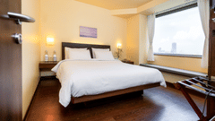 A side view of the executive room with plushy king size bed, a window with a view at Marasa Sarovar Portico, Rajkot