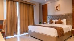 A large bed of a Super Deluxe Room at Montclair Ananta, Elite
