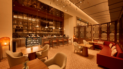 Mahua Bar at Prachi Sarovar Premiere, Bhubaneswar, with tables, armchairs, a display counter, bar stools, and a long sofa arrangement.