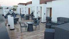 An overview of the open terrace restaurant with seating arrangements at Pride Biznotel Canopus Digha