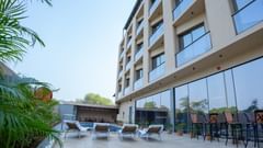 Facade of Pride Elite Daman with a pool and lounge chairs.