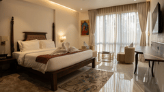 Image of suite with wooden framed bed and a large windows on the side at Pride Elite Daman.