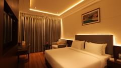 view of the king size bed with comfortable sofas of Deluxe Room at Pride Elite, Haridwar