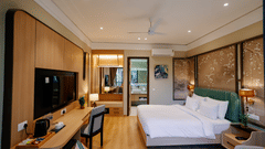 Pride Premier Alwar | A room with a large bed, bedspreads, pillows, a television, and mirrors