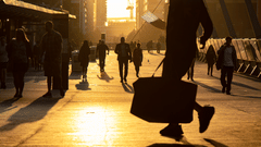 people walking down a sunlit road with the reflection of the sun on the ground