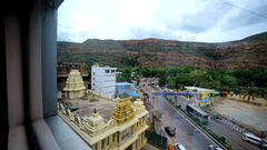 A shot of the bypass taken from the window of the room of the hotel featuring a temple on the road side.