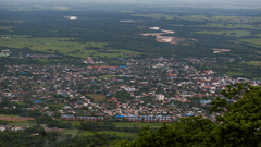 An aerial view of a town nestled in a valley surrounded by green hills.