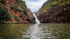 a waterfall in the centre of a mountain flowing down to a lake. It is one of the best Tirupati Photoshoot Places