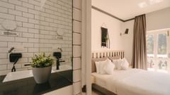 Contemporary bedroom with white interiors and a plant-themed decor at Richmonde Ananta Elite, Goa.