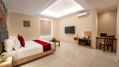 Spacious deluxe room with modern interiors, comfortable bed and seating area at Rivido - Manyata