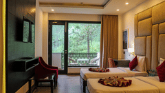 A modern hotel room with two twin beds featuring padded beige headboards and decorative throws