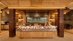 Buffet counter with wooden decor and warm lighting in a rustic restaurant setting - Royal Tulip, Chitwan