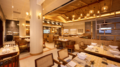 Buffet station in a modern dining area with high ceilings and columns - Royal Tulip, Chitwan