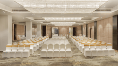 A spacious banquet hall at Royal Tulip, Kathmandu, with rows of chairs facing a distant stage.