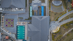 Bird's-eye view of Royal Tulip Shivapuri National Park - Kathmandu showing the swimming pool, rooftops, stone walkways, and outdoor courtyard.