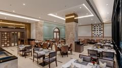 A stylish dining area in a restaurant in Ajmer featuring elegant decor, plush seating, and a relaxed ambience - Sarovar Portico, Ajmer