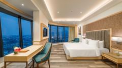 Well-lit Junior Suite with floor-to-ceiling windows at Sarovar Portico, Ajmer.