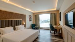 the Superior room featuring a king-sized bed, a seating area, and large windows offering scenic views