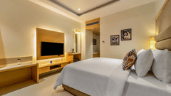 An overview of the Deluxe double room with a king bed and tv at Shyama Sarovar Portico Orai